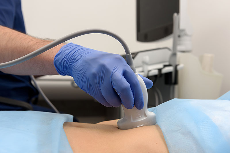 Woman undergoing an ultrasound examination to assess the stage of pregnancy before abortion treatment